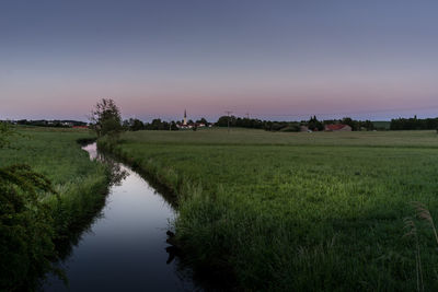 Scenic view of field against clear sky at sunset