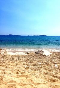 Scenic view of beach against clear blue sky