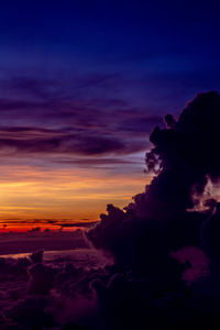 Scenic view of sea against dramatic sky at sunset