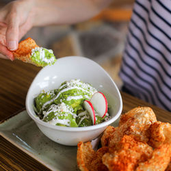 Close-up of hand holding food on table