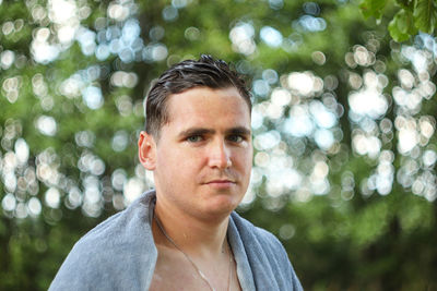 Young man looking away while standing outdoors