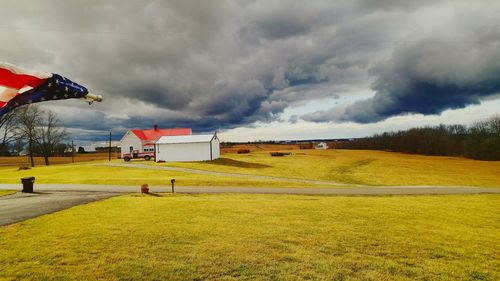 Scenic view of grassy field against cloudy sky