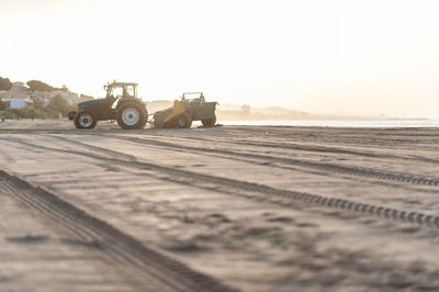 Tire tracks on field against clear sky