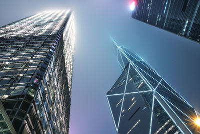 Low angle view of illuminated buildings against clear sky at night