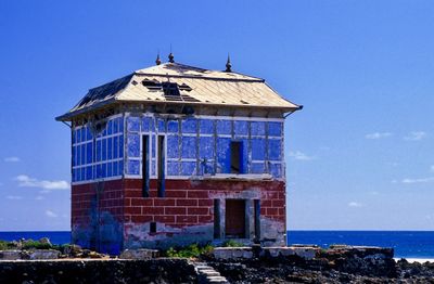 Building by sea against blue sky