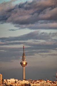 Illuminated buildings in city against sky during sunset