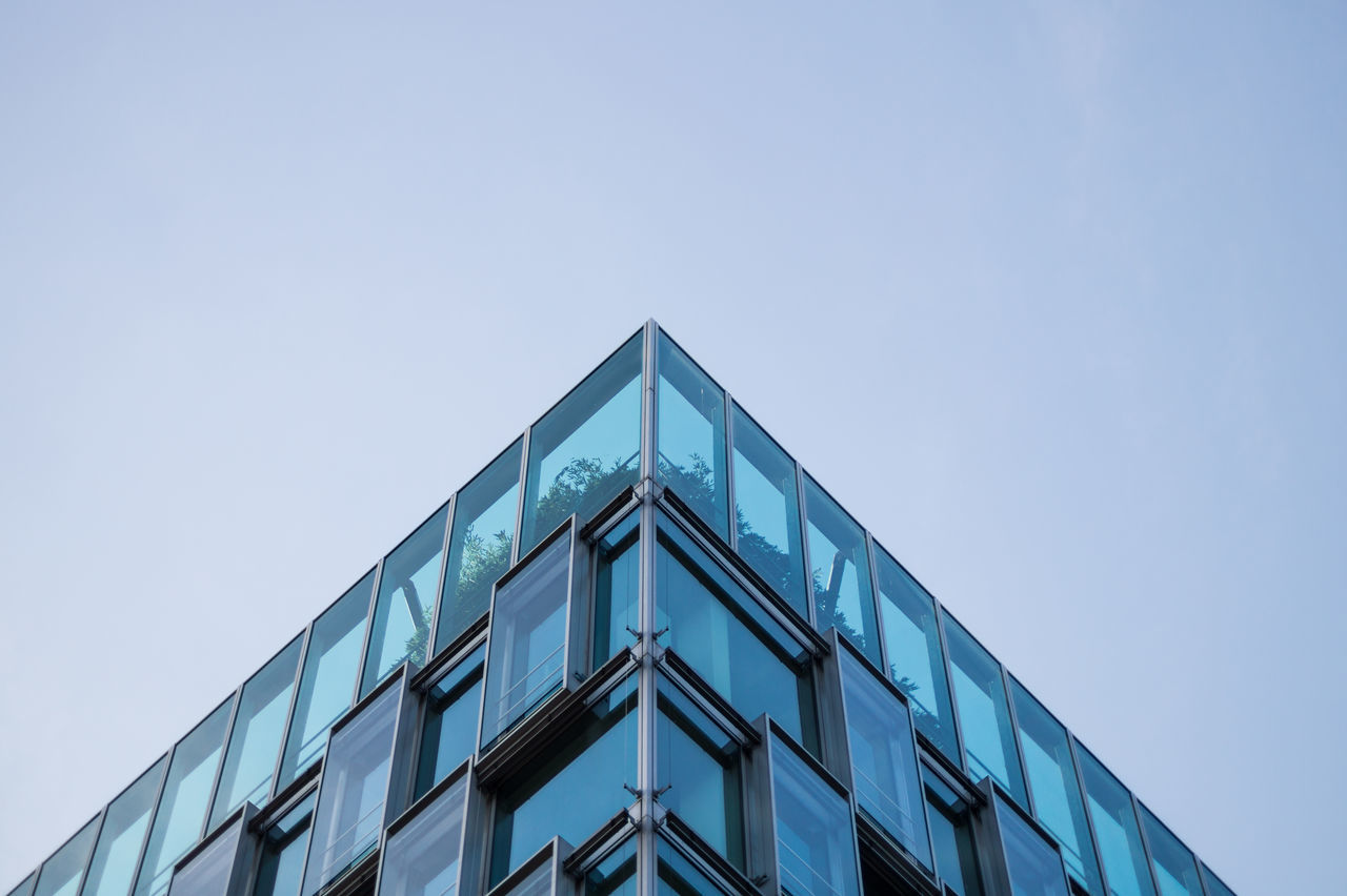 architecture, building exterior, low angle view, built structure, clear sky, building, modern, window, office building, city, copy space, glass - material, sky, day, reflection, tall - high, high section, no people, outdoors, tower