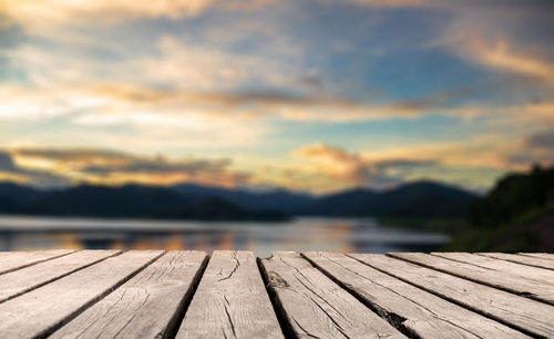 Pier over lake against sky during sunset