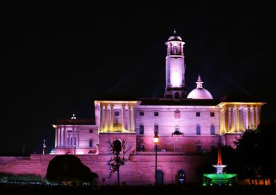 Illuminated building against sky at night