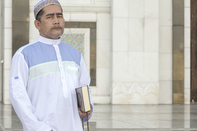 Portrait of man standing at mosque