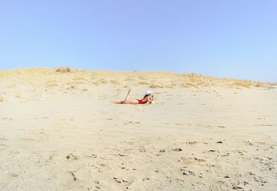 People on beach against clear sky