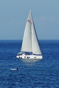Sailboat sailing on sea against sky