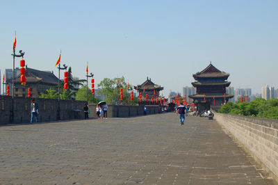 Group of people in front of building against clear sky