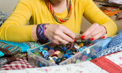 Close-up of woman holding buttons in box