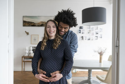 Smiling pregnant couple in living room