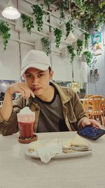 Portrait of teenager boy eating food at restaurant