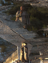 Full length of couple with reflection on water