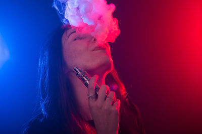 Close-up portrait of woman smoking cigarette