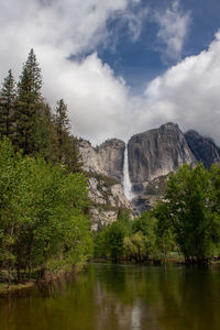 Scenic view of waterfall in forest against sky