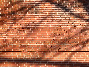 Full frame shot of brick wall with shadow during sunny day 