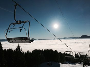 Low angle view of ski lift against sky during winter