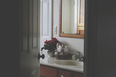 Flower vase on table by window at home