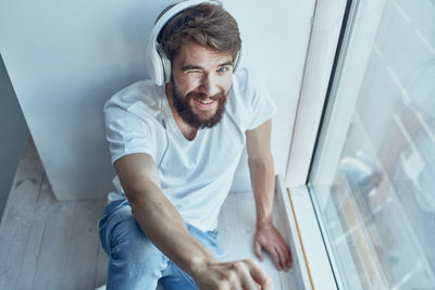 Young man looking through window