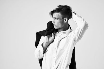 Young man looking away against white background