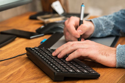 Midsection of man using laptop on table