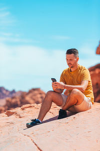 Young woman sitting on sand at beach