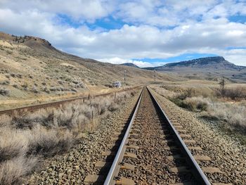 View of railroad tracks against cloudy sky