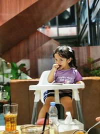 Cute girl sitting on chair at cafe