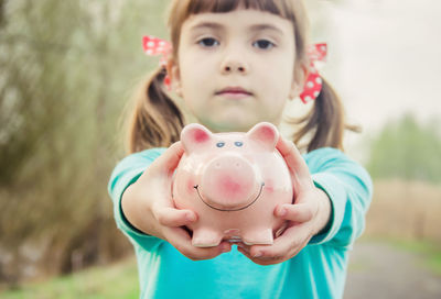 Portrait of cute boy holding piggy bank