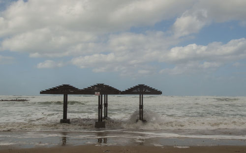 Lifeguard hut on beach against sky