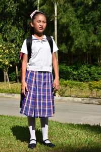 Full length of girl standing against plants