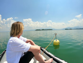 Rear view of woman on sea against sky