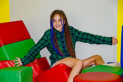 Portrait of young woman sitting on sofa at home