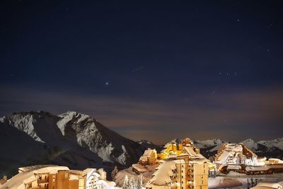 Scenic view of snowcapped mountains against sky at night