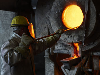 Industry, worker at furnace during melting copper, wearing a fire proximity suit