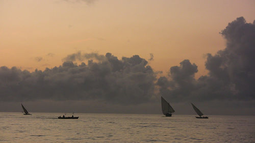 Boat sailing in sea at sunset