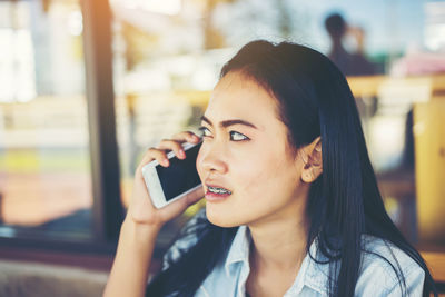 Portrait of young woman using mobile phone