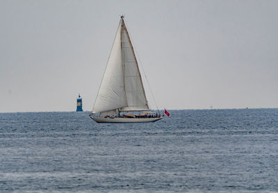 Sailboat sailing on sea against clear sky