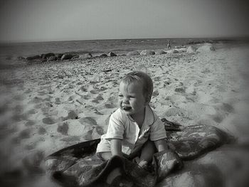 Rear view of man sitting on beach