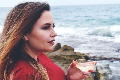 Portrait of woman drinking water from beach