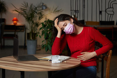 Sick woman sitting at home