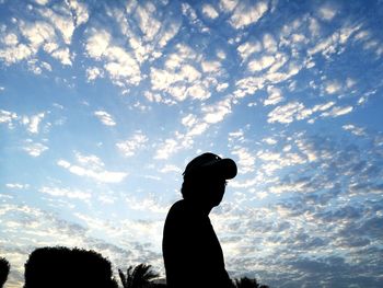 Silhouette boy standing against sky