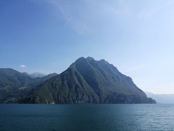 Scenic view of sea and mountains against blue sky