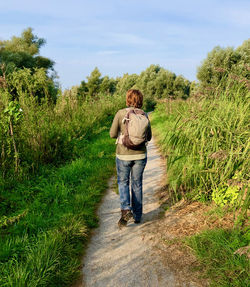 Rear view of woman walking on field