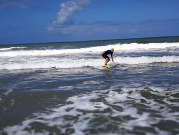 Man surfing in sea against sky