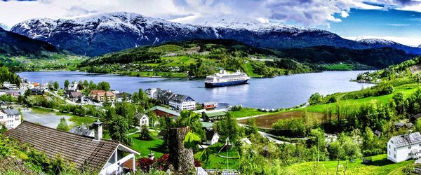 Scenic view of lake by trees and mountains against sky